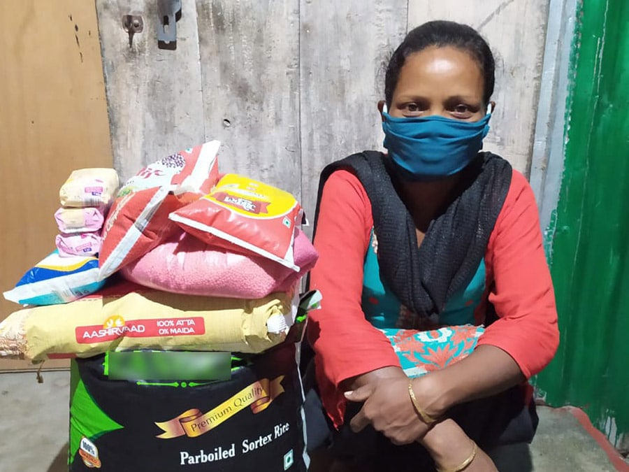Intialainen kristitty Devi Open Doorsilta saamansa ruoka-avun kanssa