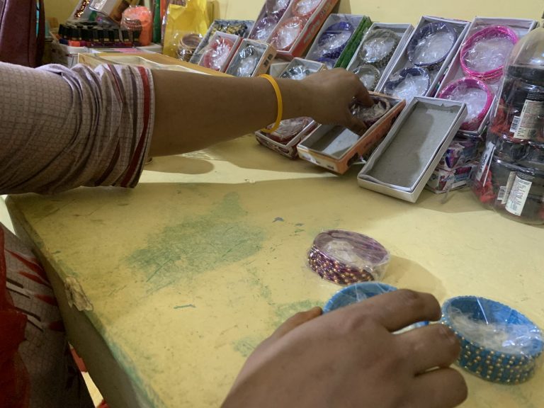 Kuvassa näkyvat Shivanin kädet järjestelemässä kauneushoitolassa myytäviä rannekoruja.