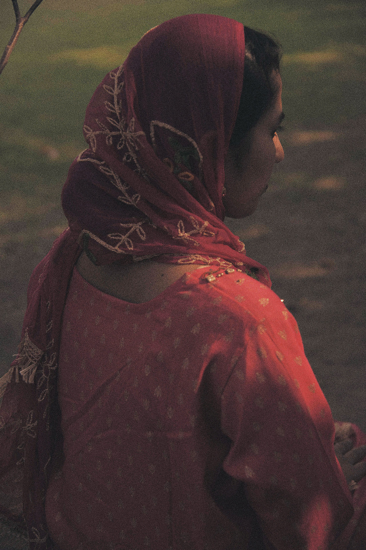 Mehr, vainottu Intialainen naiskristitty, istuu yksin talonsa pihalla.
