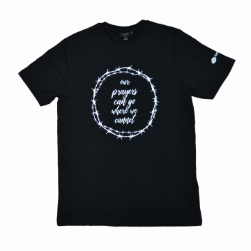 Musta t-paita, kuvassa piikkilankaympyrä, jonka sisällä teksti "our prayers can go where we cannot"