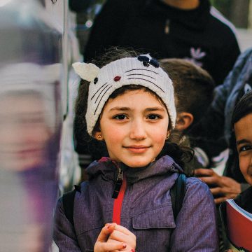 Lapsi Lähi-idästä hymyilee pupua esittävä pipo päässään