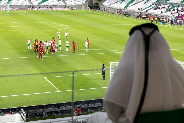 Qatarilainen mies seuraamassa Qatarin jalkapallojoukkueen ystävyysottelua jalkapallostadionin katsomossa.