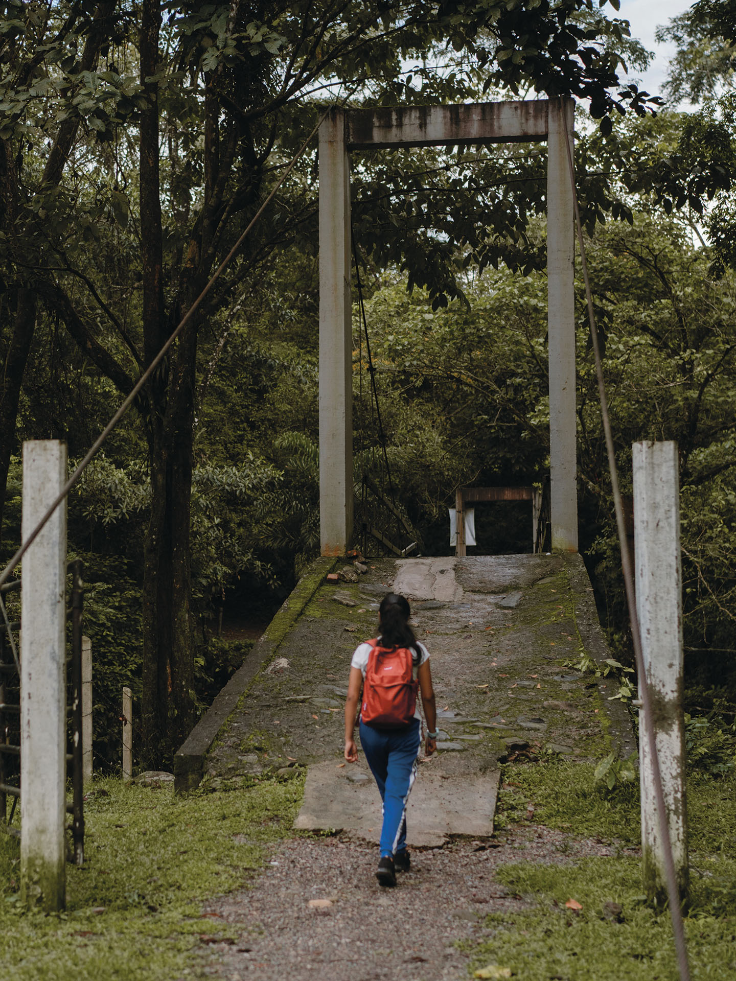 Valentina kävelee kotiansa kohti Kolumbian metsäisessä maisemassa