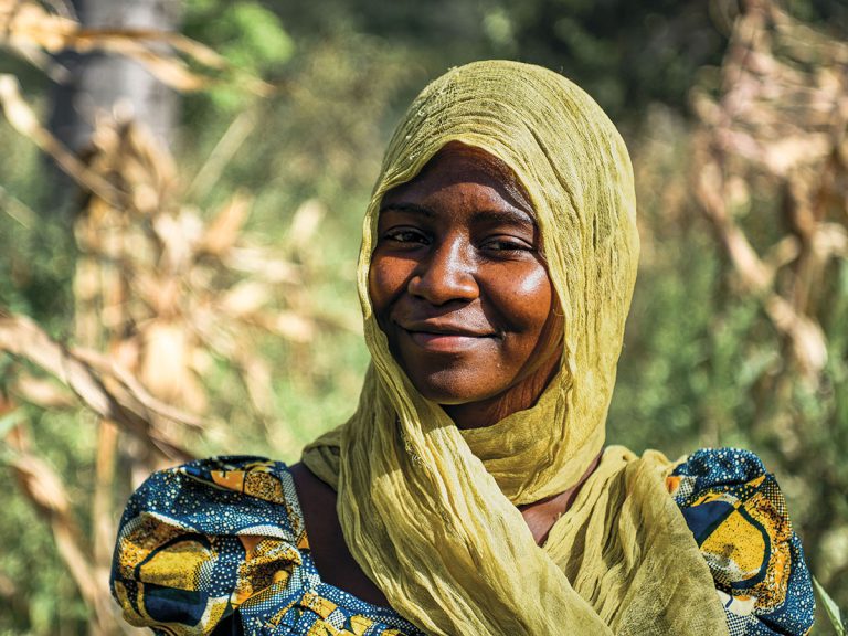Afrikkalainen, nyt edesmennyt, nuori kristitty Mary hymyilee kauniisti Afrikan auringon alla
