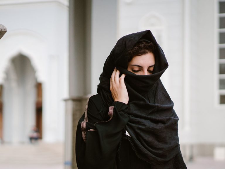 A woman walking in a mosque, lower part of face veiled
