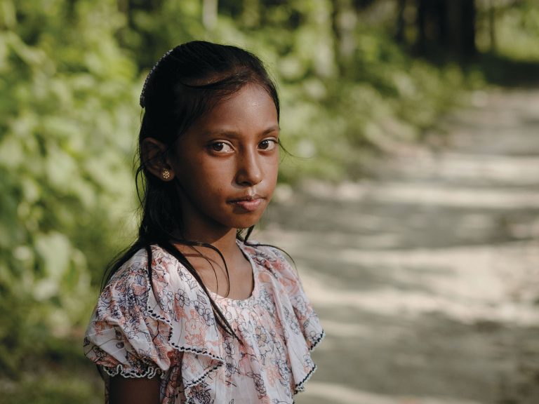 Bangladeshilainen tyttö katsoo kameraan