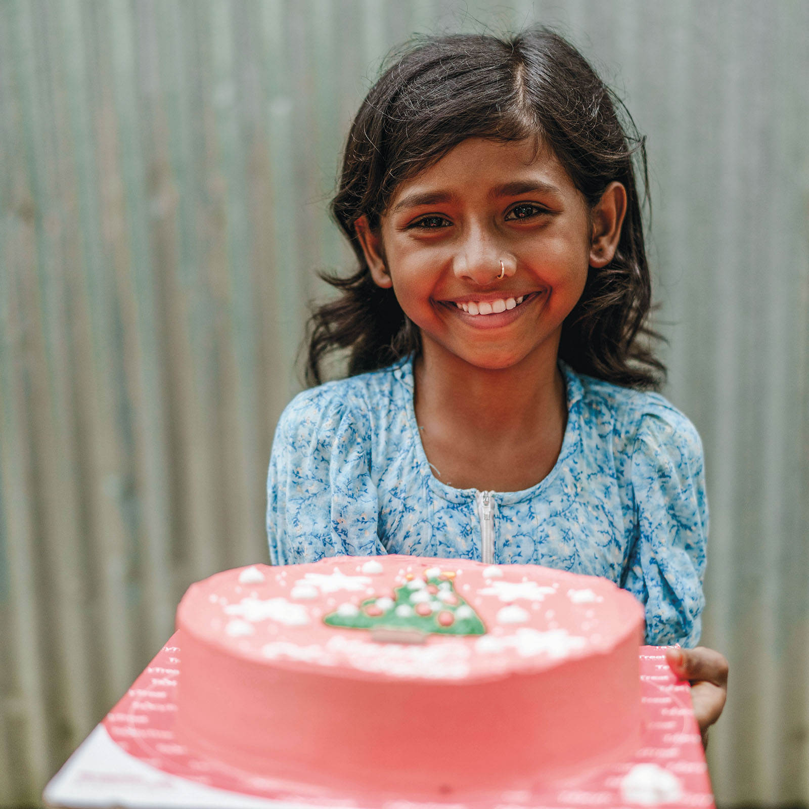 Bangladeshilainen tyttö kakun kanssa