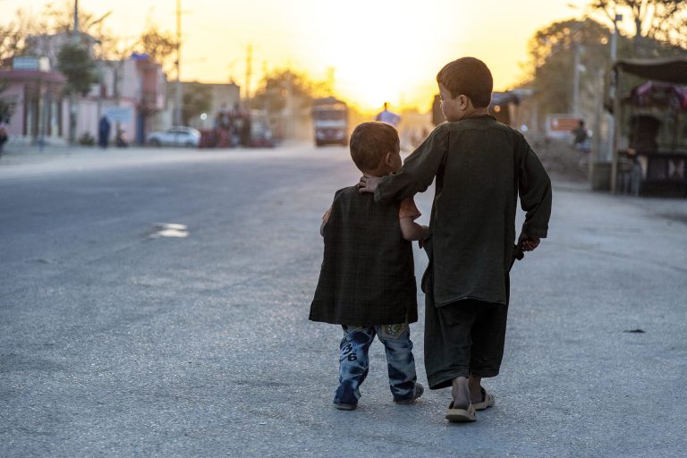 Two boys walk down the road in Afghanistan