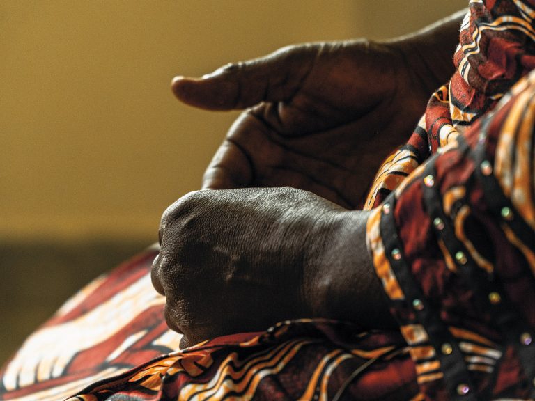Afrikkalaisen naisen kädet perinteisen asun päällä