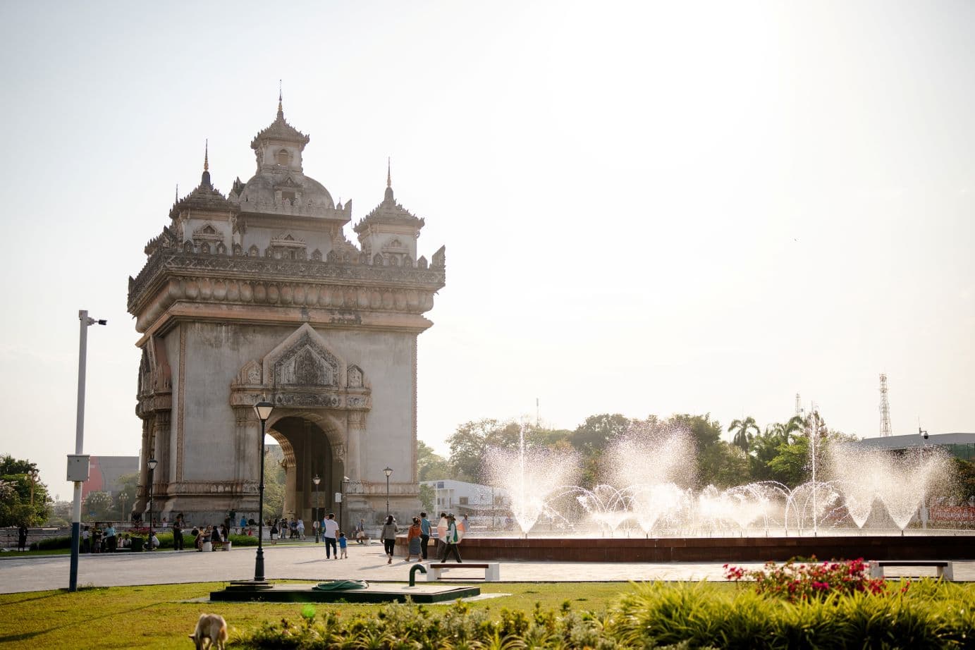 Aasialainen suuri rakennus, jonka edessä ihmisiä ja vesilammikko, jossa suihkulähteitä.