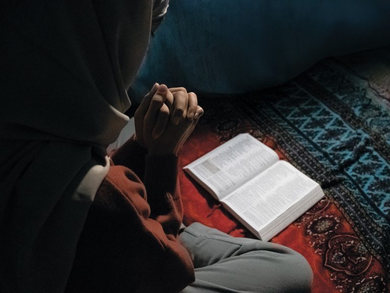 Filippiinilainen tytto Inya rukoilee Raamatun aarella