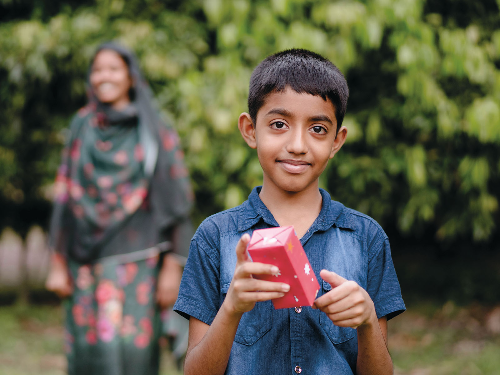 Poika pitelee pientä joululahjapakettiä kädessään