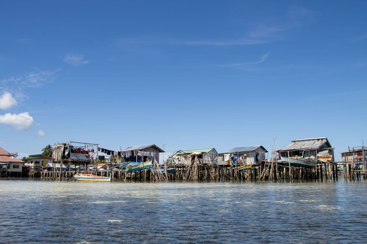 Puurakennuksia paalujen varassa meren päällä.