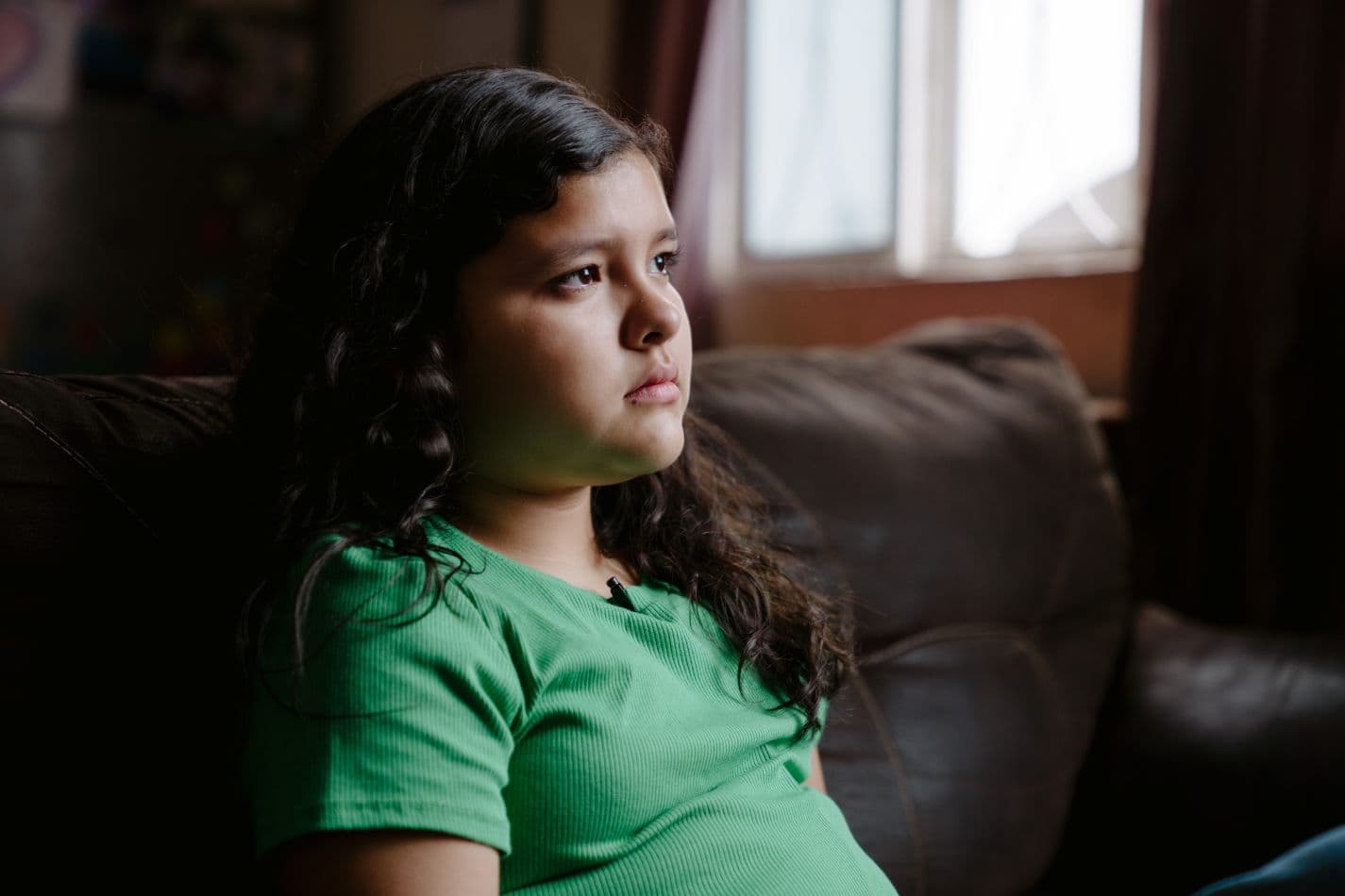 Tyttö istuu sohvalla.