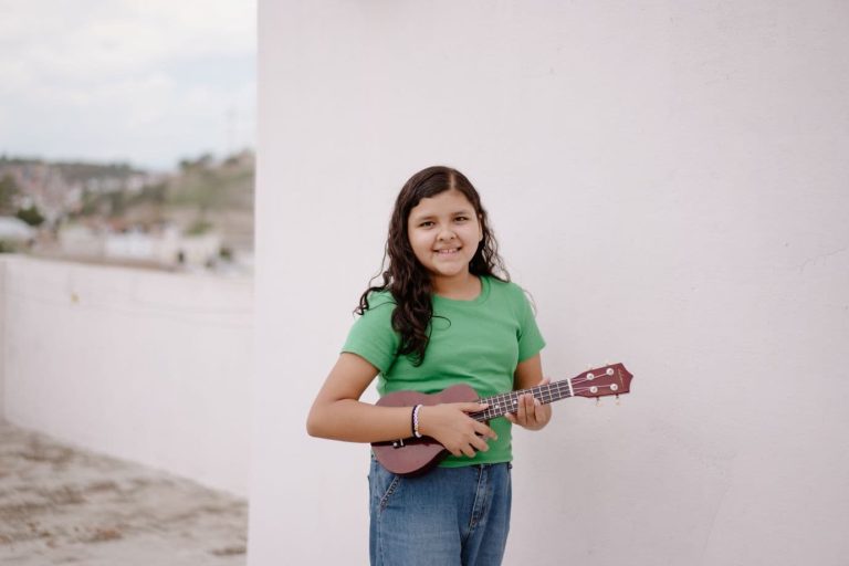 Alakouluikäinen tyttö käsissään ukulele.