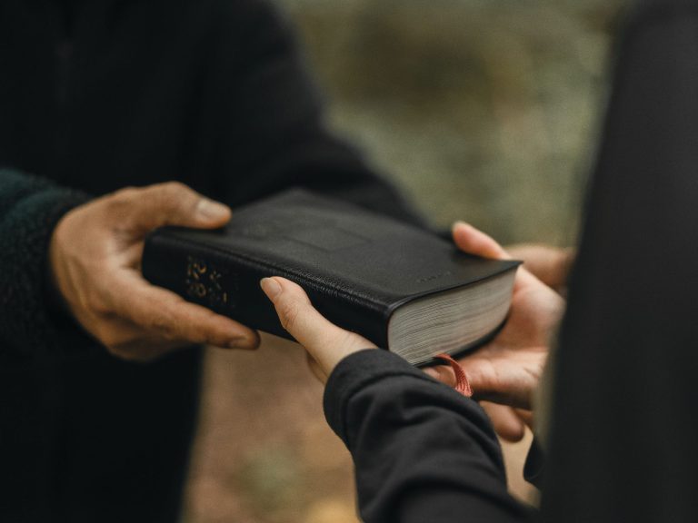 Ihminen antaa toiselle Raamatun