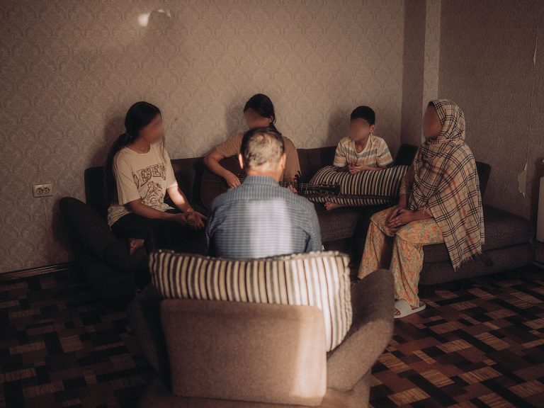 Perhe Lähi-idästä ylistämässä Jumalaa kotonaan