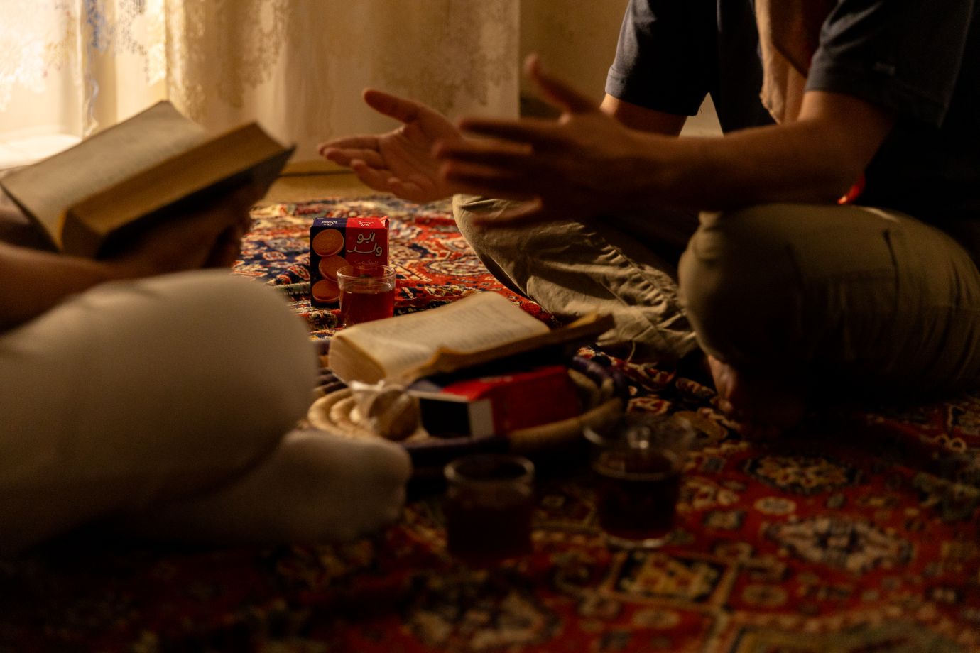 Ihmisiä lattialla Raamatun äärellä.