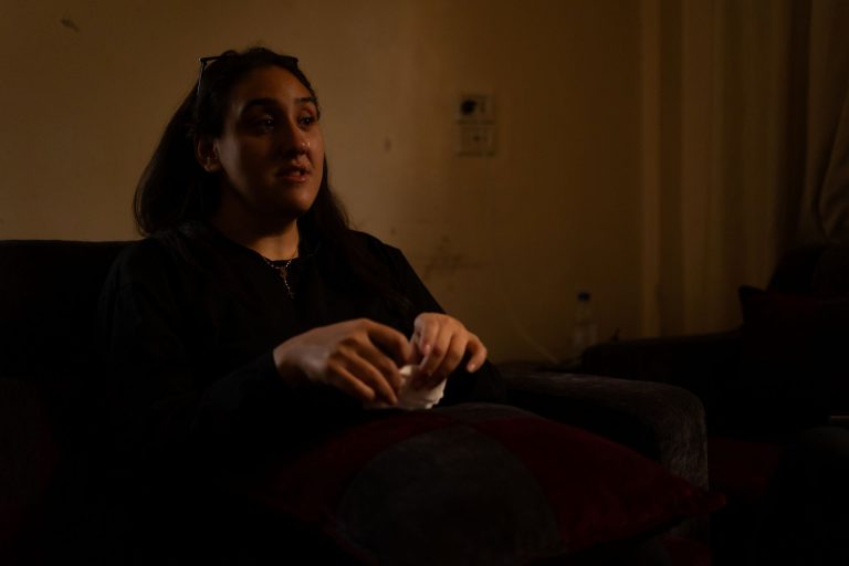 Nainen kyyneleet silmissään hämärässä huoneessa.