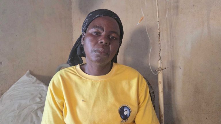 nigerialainen äiti Sabina istuu kotonaan surullinen ilme kasvoillaan
