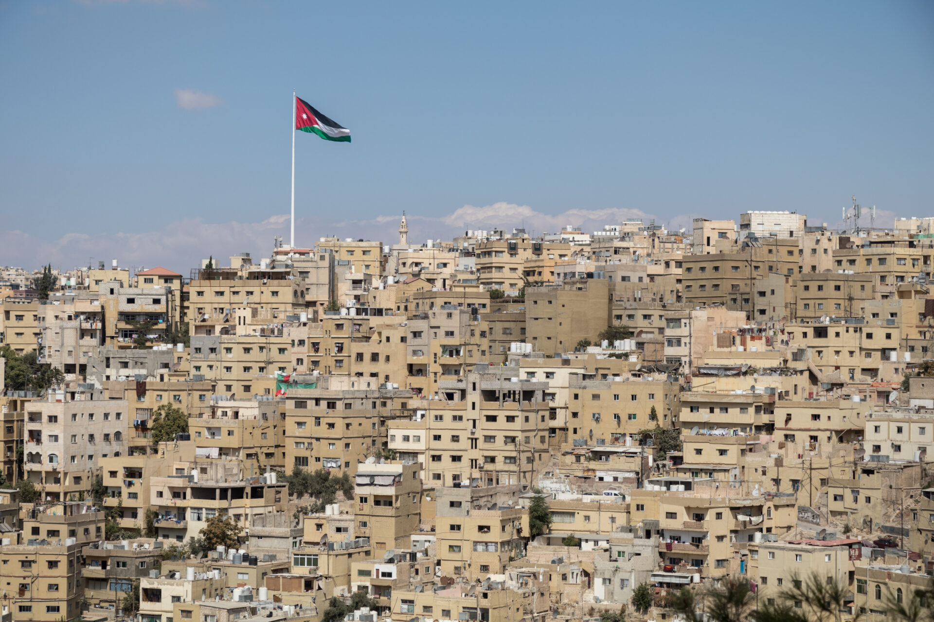 Jordanian lippu kukkulalla, joka on täynnä kellertäviä taloja.